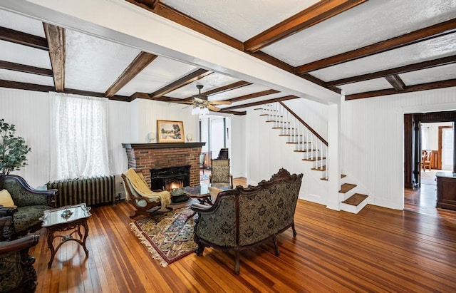 430 Montauk Hwy, East Moriches, NY 11940 - living area featuring a fireplace, stairway, a ceiling fan, radiator heating unit, and wood-type flooring