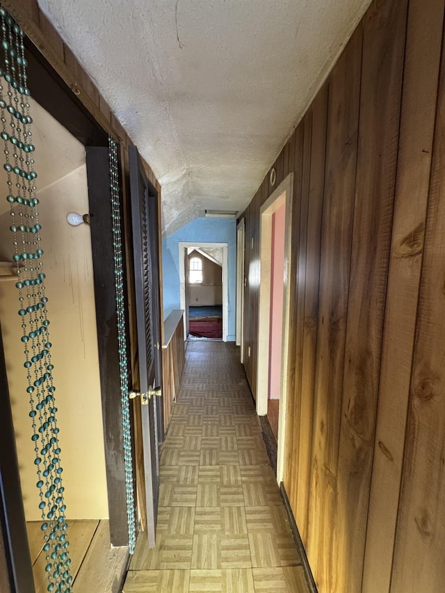 10 N Franklin St, Athens, NY 12015 - corridor featuring vaulted ceiling, wooden walls, and a textured ceiling