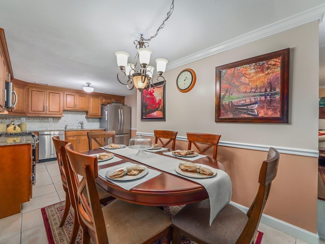 dining area with a chandelier, crown molding, light tile patterned floors, and baseboards