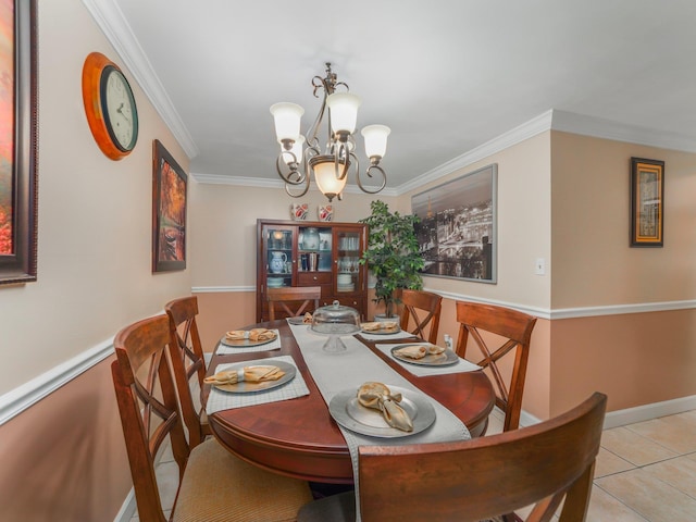 dining room featuring crown molding, light tile patterned floors, baseboards, and a chandelier