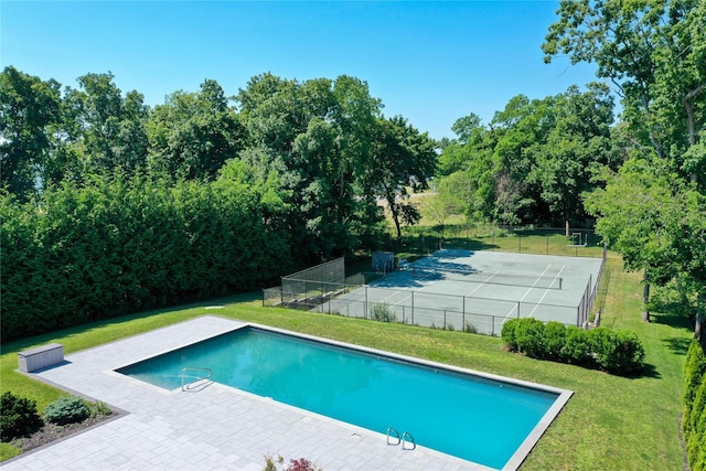 pool featuring a lawn, fence, and a patio