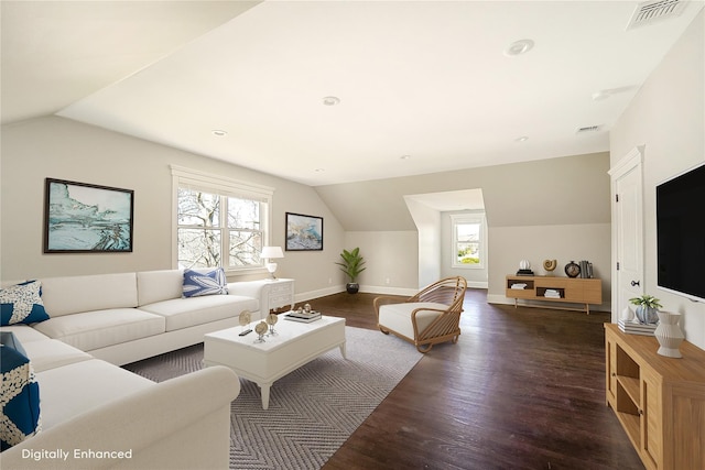 living area featuring wood finished floors, baseboards, vaulted ceiling, and visible vents