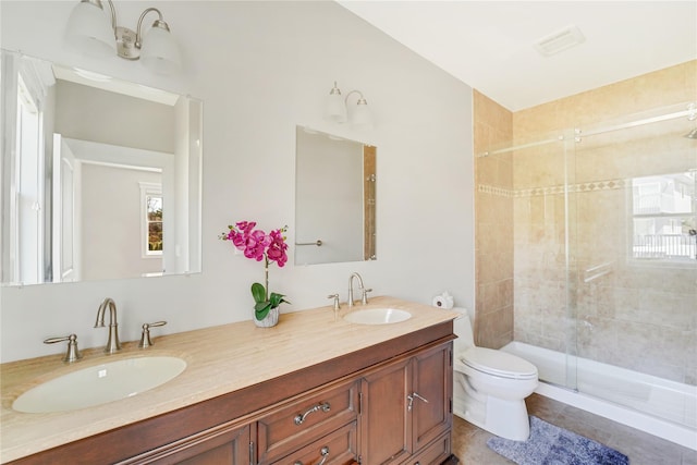full bath featuring a stall shower, double vanity, toilet, and a sink