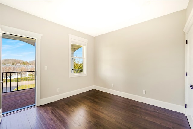 empty room with baseboards, a healthy amount of sunlight, and dark wood finished floors