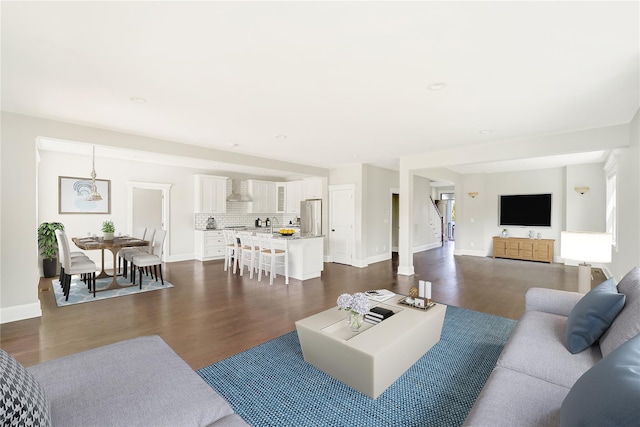 living area featuring baseboards and dark wood finished floors