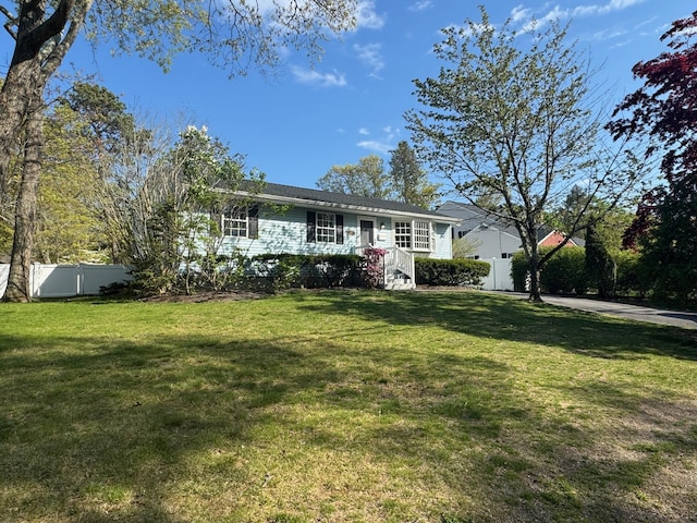 split foyer home with fence and a front yard