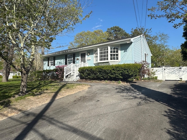 ranch-style house featuring a gate and driveway