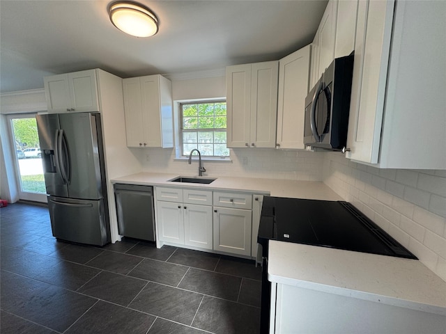 kitchen with stainless steel fridge, a sink, dishwashing machine, and plenty of natural light