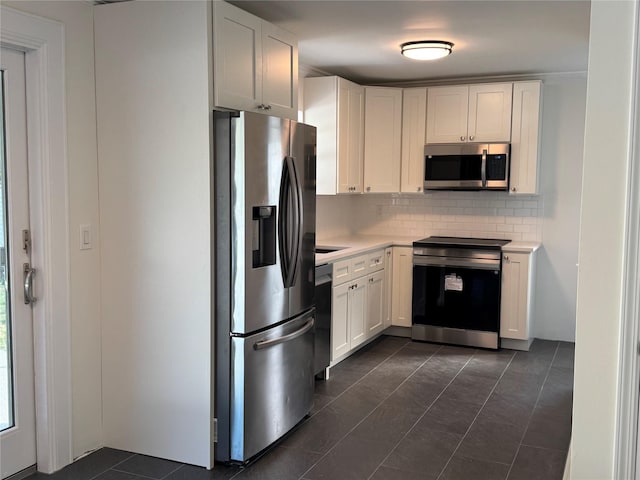 kitchen with light countertops, appliances with stainless steel finishes, tasteful backsplash, and white cabinets