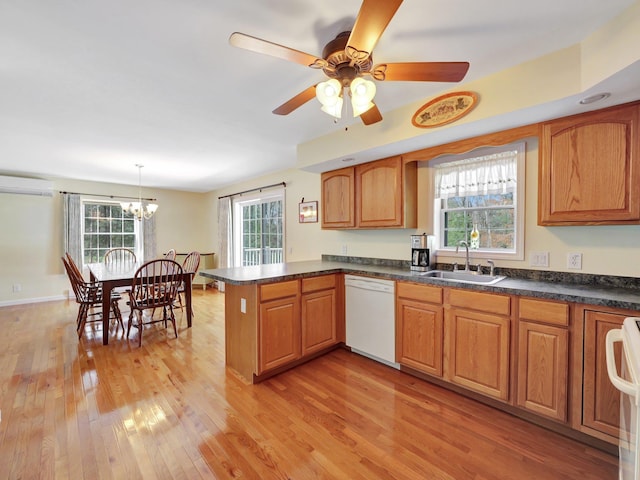 25 Devlin Rd, Eldred, NY 12743 - kitchen with white dishwasher, a sink, an AC wall unit, light wood-style flooring, and a peninsula