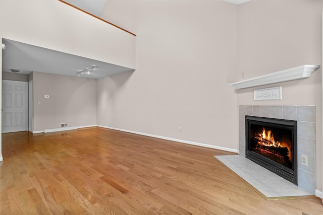 5702 Manor Dr Unit 5702, Peekskill, NY 10566 - unfurnished living room featuring a fireplace, wood finished floors, baseboards, and track lighting