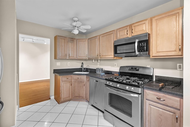 5702 Manor Dr Unit 5702, Peekskill, NY 10566 - kitchen with stainless steel appliances, a sink, light brown cabinetry, and dark countertops