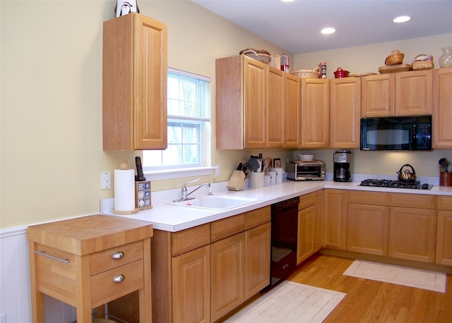11 Arielle Ct, Islandia, NY 11749 - kitchen with light countertops, a sink, light wood-type flooring, light brown cabinets, and black appliances