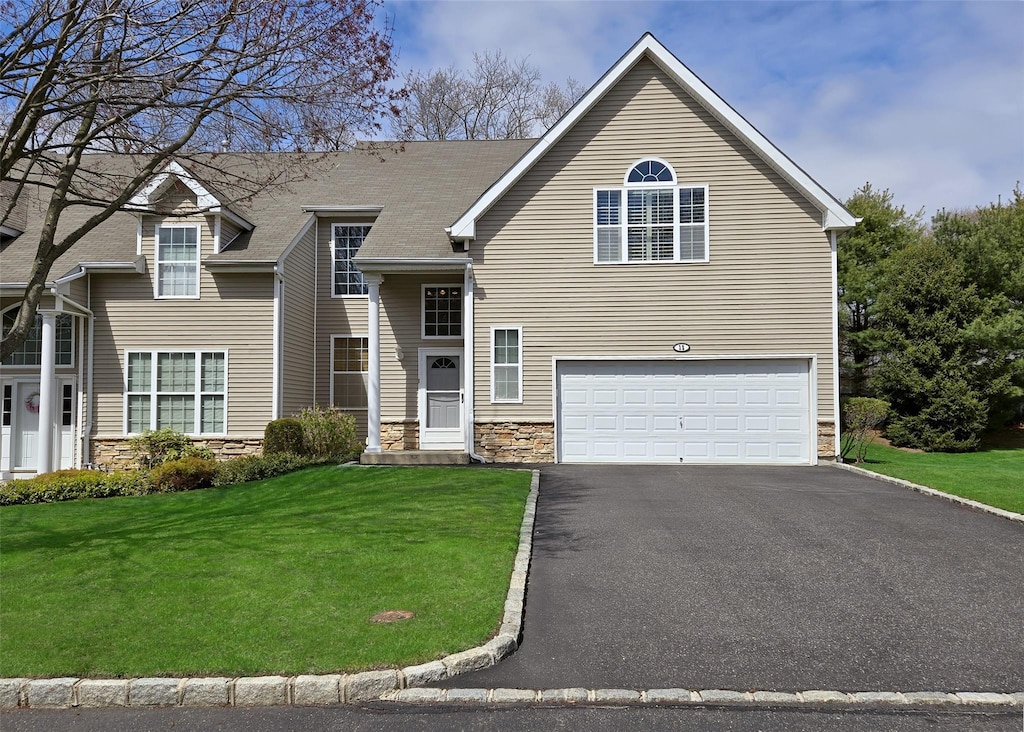 11 Arielle Ct, Islandia, NY 11749 - view of front of house featuring stone siding, aphalt driveway, a front yard, and a garage