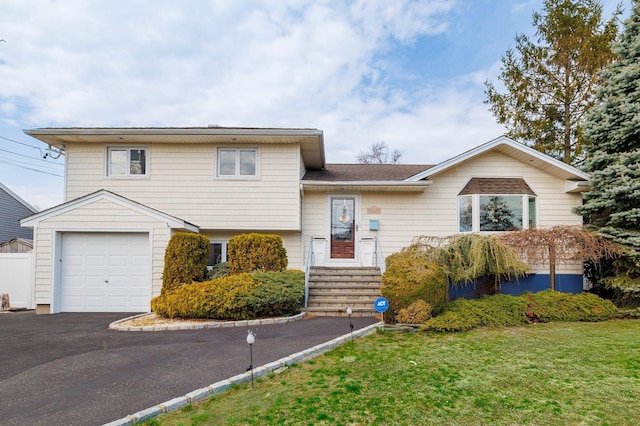 split level home with an attached garage, driveway, and a front yard