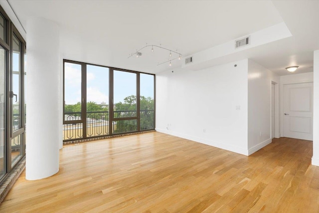 412 Kings Hwy Unit 6C, Brooklyn, NY 11223 - empty room with light wood finished floors, track lighting, floor to ceiling windows, and baseboards