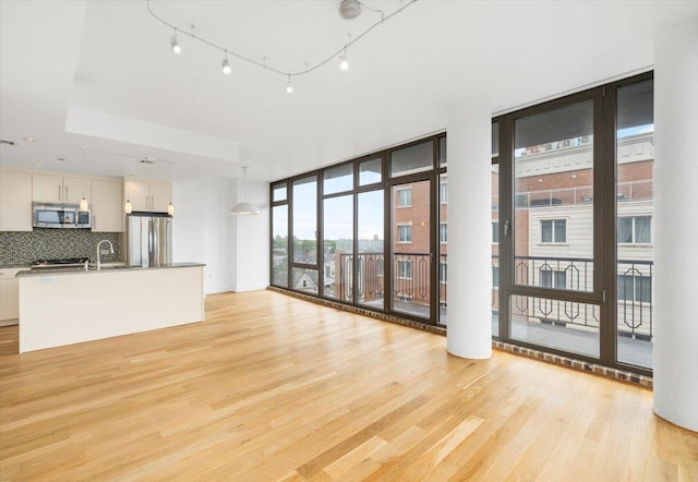 412 Kings Hwy Unit 6C, Brooklyn, NY 11223 - unfurnished living room featuring a wall of windows and light wood-type flooring