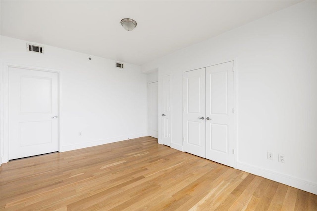 412 Kings Hwy Unit 6C, Brooklyn, NY 11223 - unfurnished bedroom featuring light wood-style floors, baseboards, and two closets