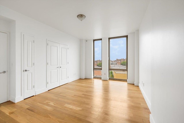 412 Kings Hwy Unit 6C, Brooklyn, NY 11223 - unfurnished bedroom with light wood-type flooring, floor to ceiling windows, access to outside, and baseboards
