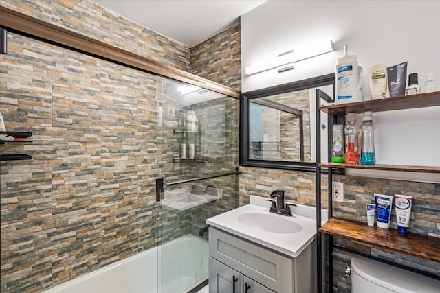 bathroom with bath / shower combo with glass door, toilet, and vanity