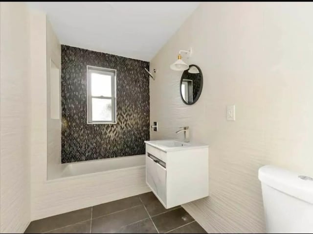 full bath with vanity, toilet, tile patterned flooring, and tiled shower