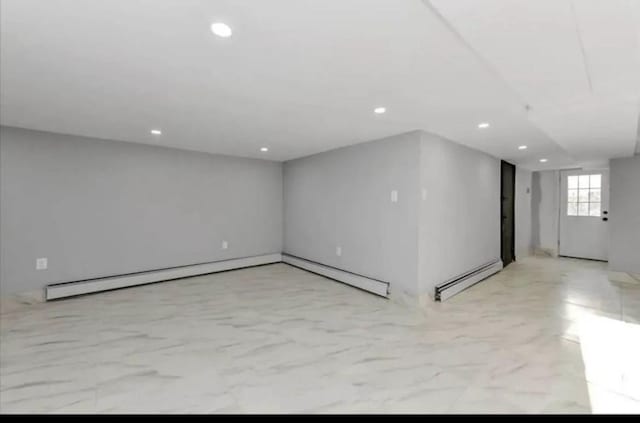 below grade area with marble finish floor, a baseboard heating unit, and recessed lighting