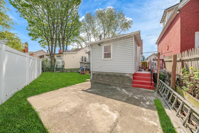 back of house featuring a yard, a patio, and a fenced backyard