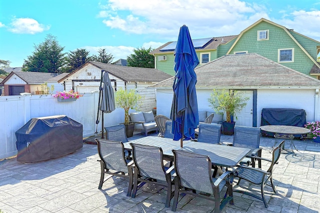 view of patio / terrace with area for grilling, fence, outdoor dining area, and an outdoor structure