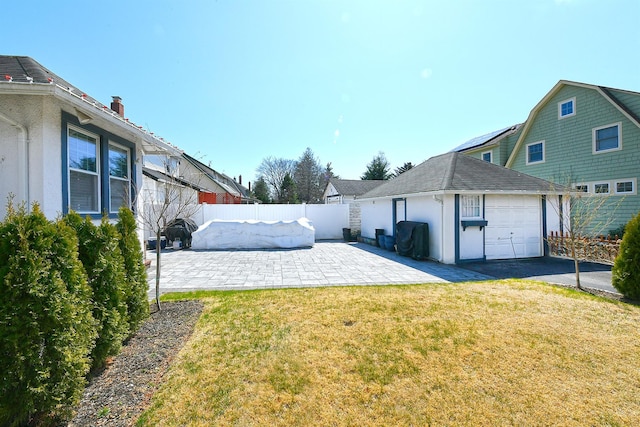 view of side of home featuring a yard, a patio area, a garage, a fenced backyard, and driveway