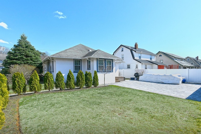 exterior space featuring a patio, stucco siding, fence, and a front yard