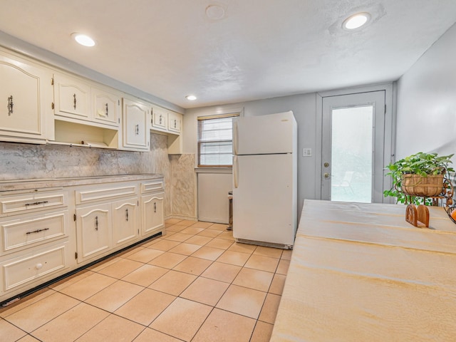 82 Coventry Gdns, Lynbrook, NY 11563 - kitchen with freestanding refrigerator, light tile patterned floors, tasteful backsplash, light countertops, and recessed lighting