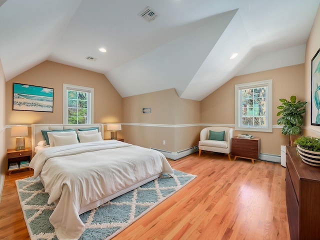 bedroom with light wood-style floors, visible vents, and a baseboard heating unit