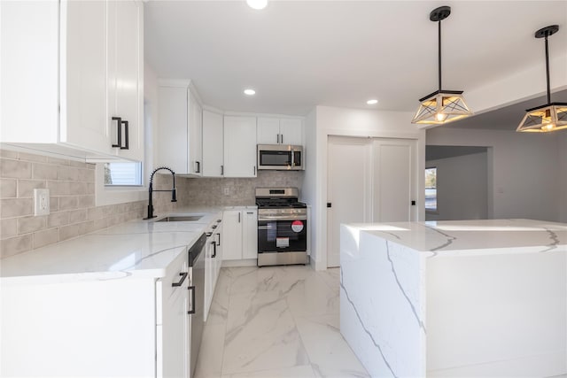 kitchen featuring marble finish floor, appliances with stainless steel finishes, white cabinetry, a sink, and backsplash