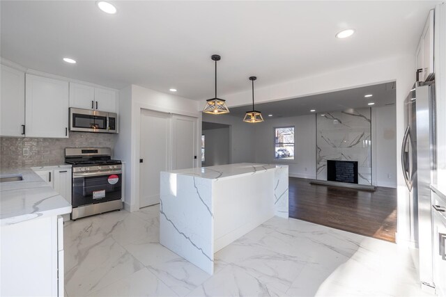 kitchen with marble finish floor, white cabinets, stainless steel appliances, and recessed lighting
