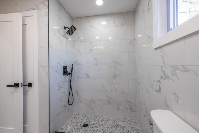 full bath with toilet and tiled shower