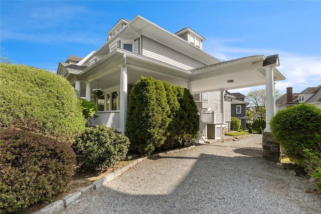view of side of property featuring covered porch