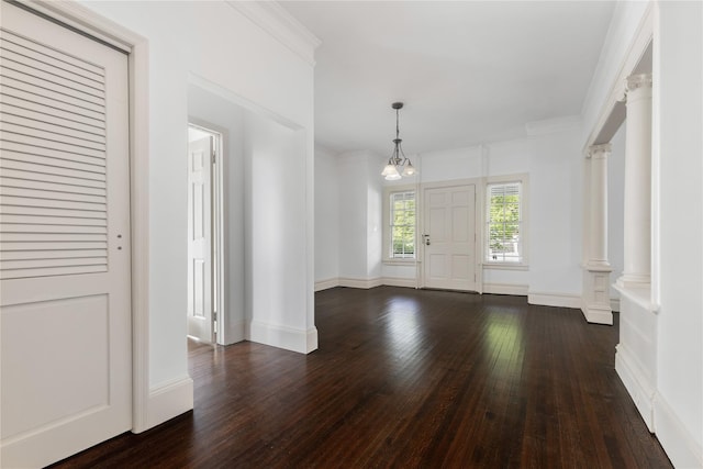 entryway with crown molding, baseboards, an inviting chandelier, and dark wood-style floors