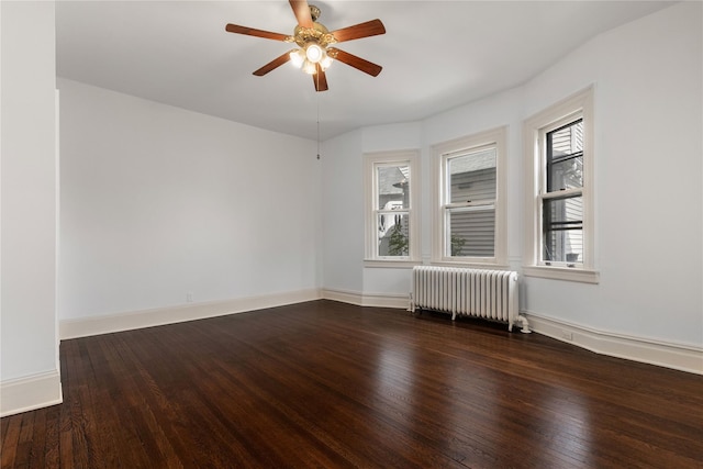 unfurnished room featuring radiator, baseboards, wood-type flooring, and a ceiling fan