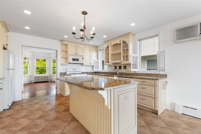 kitchen featuring a center island, cream cabinets, open shelves, radiator, and white appliances