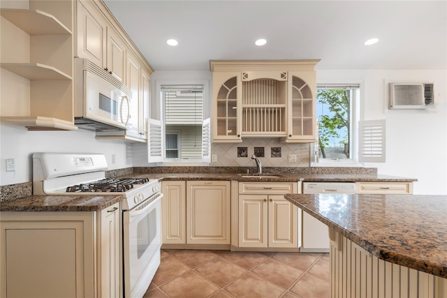 kitchen featuring cream cabinets, open shelves, a sink, and white appliances