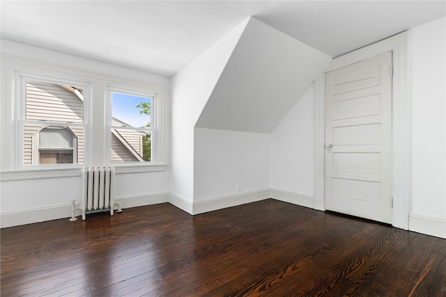 bonus room featuring radiator heating unit, baseboards, vaulted ceiling, and dark wood-style flooring
