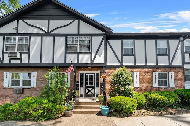 129 Parkside Dr, Suffern, NY 10901 - tudor house featuring brick siding, central AC unit, stucco siding, and cooling unit