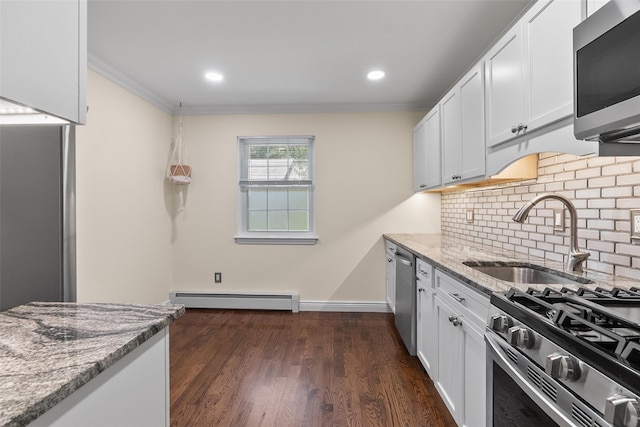 129 Parkside Dr, Suffern, NY 10901 - kitchen with appliances with stainless steel finishes, a baseboard heating unit, a sink, light stone countertops, and crown molding