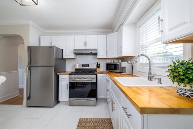 645 Hawkins Blvd, Copiague, NY 11726 - kitchen with a sink, butcher block countertops, appliances with stainless steel finishes, and under cabinet range hood