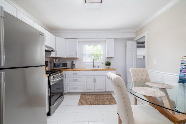 645 Hawkins Blvd, Copiague, NY 11726 - kitchen featuring under cabinet range hood, white cabinetry, a sink, and appliances with stainless steel finishes