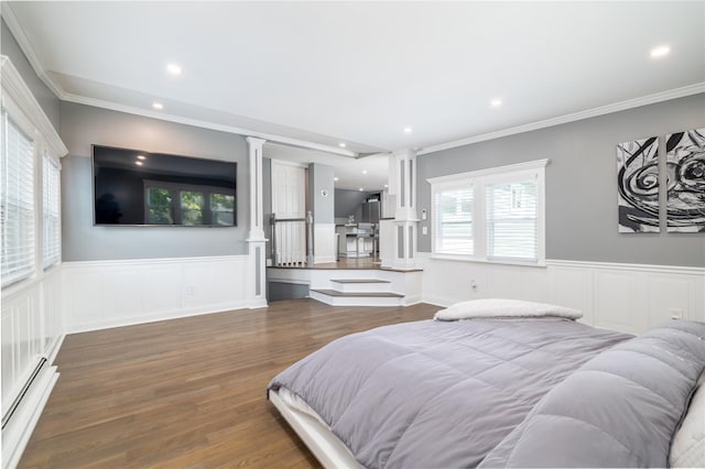 645 Hawkins Blvd, Copiague, NY 11726 - bedroom featuring a baseboard radiator, wood finished floors, a wainscoted wall, and ornate columns