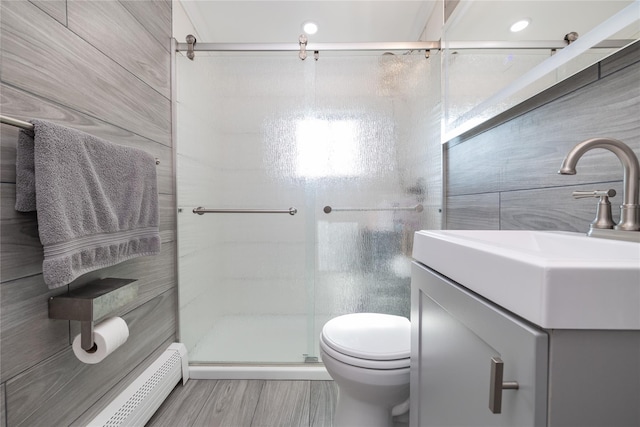 645 Hawkins Blvd, Copiague, NY 11726 - full bathroom with vanity, toilet, baseboard heating, a stall shower, and wood finished floors