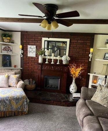 12 Bluebird Dr, Lake Luzerne, NY 12846 - living room with a fireplace with raised hearth, carpet, and ceiling fan
