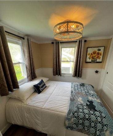 12 Bluebird Dr, Lake Luzerne, NY 12846 - bedroom featuring crown molding and a wainscoted wall