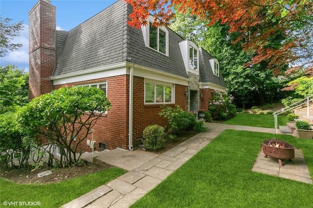 30 Appleton Pl, Dobbs Ferry, NY 10522 - view of property exterior featuring mansard roof, a fire pit, a lawn, a shingled roof, and brick siding